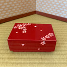 Red decorative box with floral patterns on a textured surface