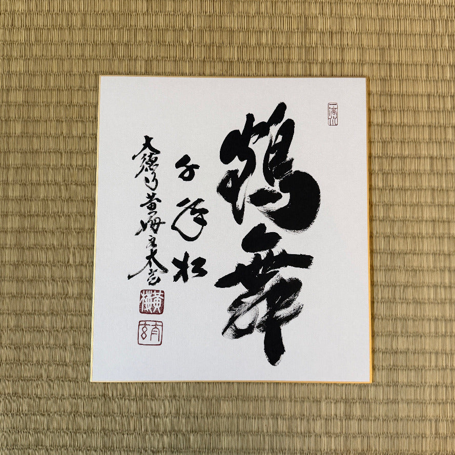 Sheet of paper with black calligraphy on a woven mat background