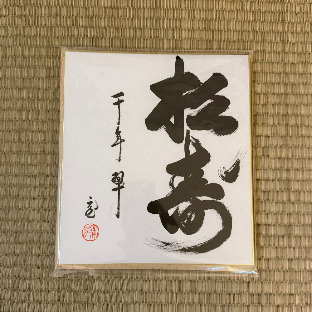 Calligraphy piece on a textured mat