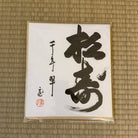 Calligraphy piece on a textured mat