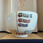 Decorative ceramic bowl with fish patterns on a wooden surface