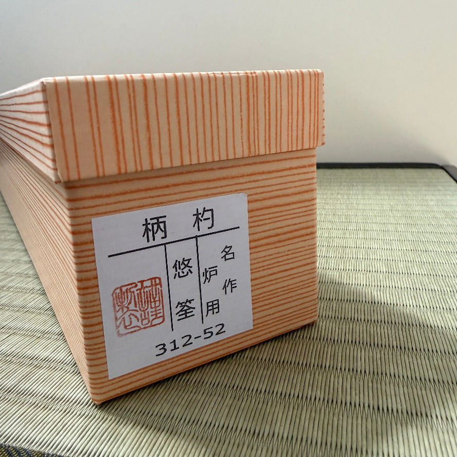 Wooden box with a label on a woven mat