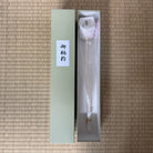 Decorative item in a box with a label on a textured surface