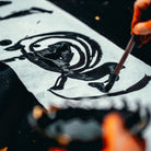 Person writing calligraphy with a brush on rice paper
