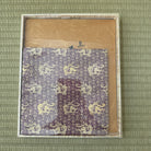 Patterned fabric in a box on a green textured background