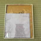 Packaged product with a gold border on a green textured background
