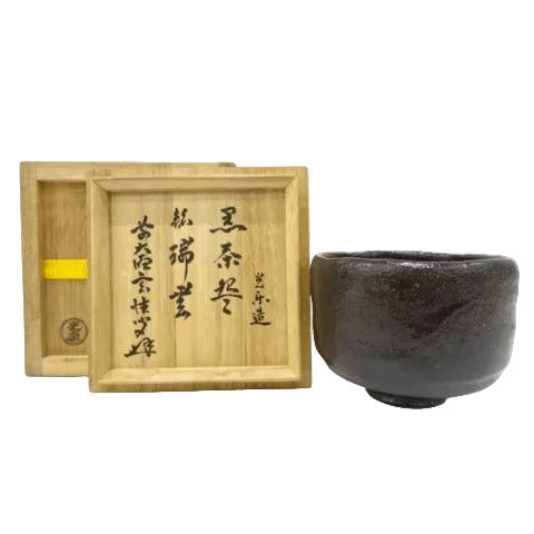 Black ceramic cup with wooden box on a white background