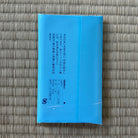 Blue rectangular object with text on a textured gray surface