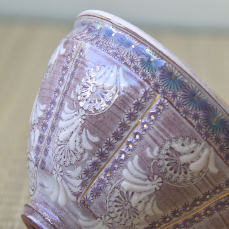 Ceramic bowl with intricate purple and white floral patterns on a neutral background