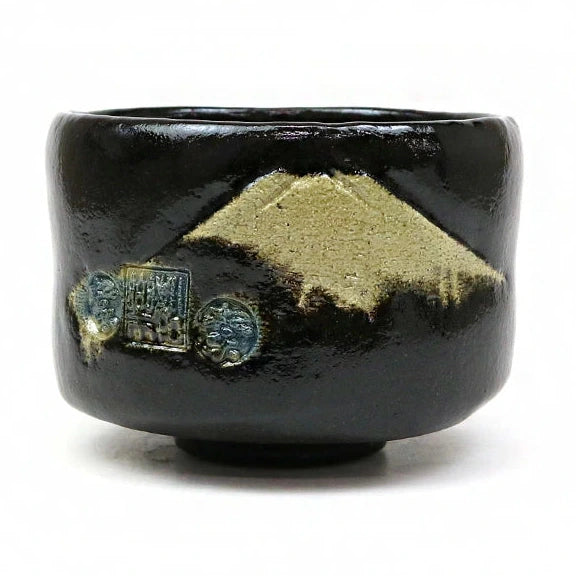 Black ceramic cup with gold mountain design on a white background