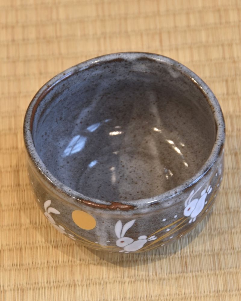 Top-down view of a matcha bowl showing a rabbit and the moon design.
