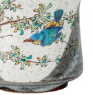 Ceramic mug with a blue bird and green leaves design on a white background