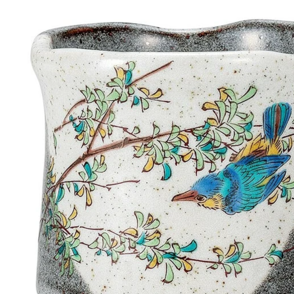 Ceramic pitcher with bird and floral design on a white background