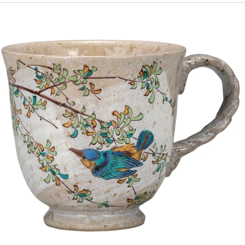 Ceramic mug with bird and branch design on a white background
