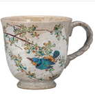 Ceramic mug with bird and branch design on a white background