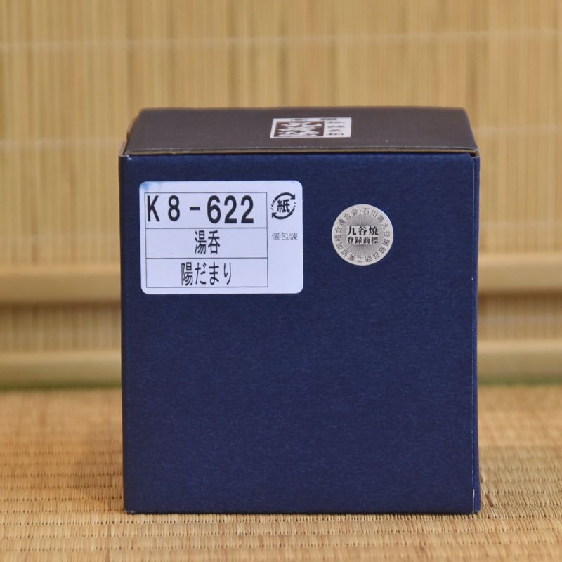 Blue box with a label on a woven mat background