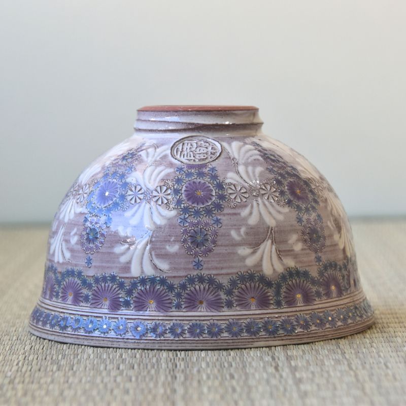 Decorative ceramic bowl with floral patterns on a textured surface