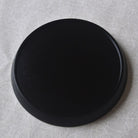 Black circular object on a textured gray surface