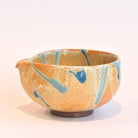 Ceramic bowl with blue abstract patterns on a beige background
