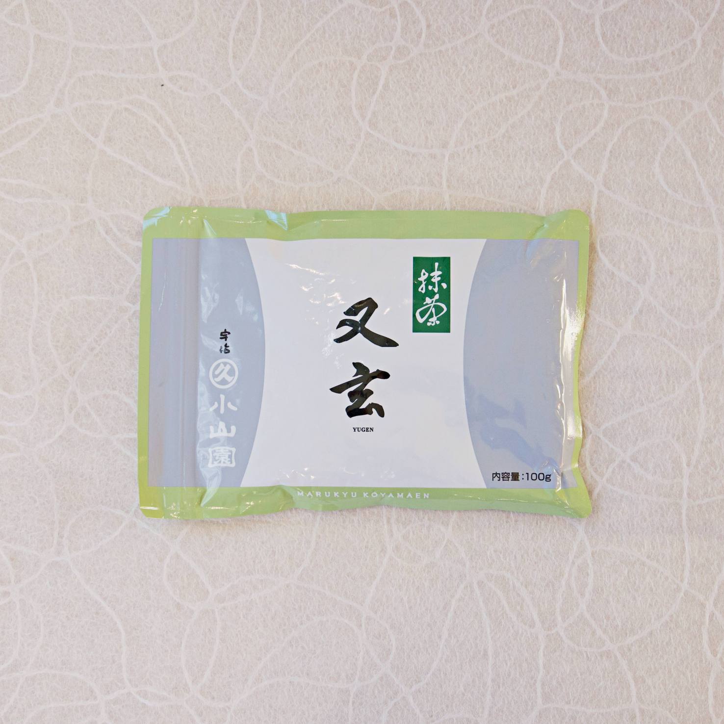 A bag of YUGEN Marukyu Koyamaen Matcha with Japanese characters on the label, predominantly in a light blue and green color scheme.