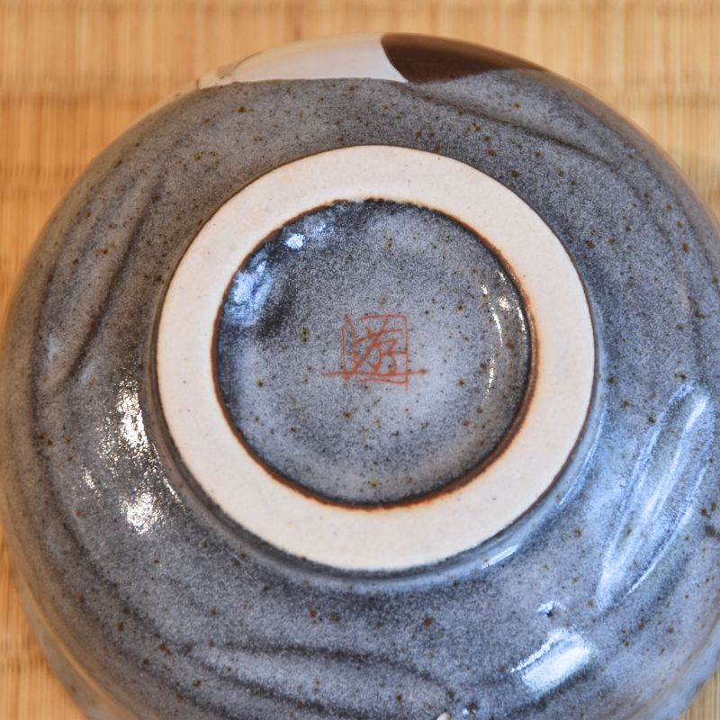 Close-up of a ceramic bowl with a textured surface on a wooden background