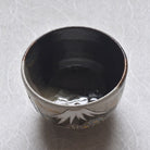 Ceramic cup with floral design on a textured white surface