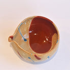 Ceramic bowl with brown interior and beige exterior on a white background