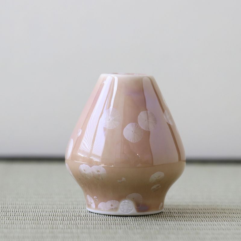 Matcha whisk stand holder with white patterns on a light gray surface