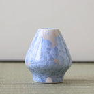 Matcha Whisk stand with blue and white cracked pattern on a neutral background