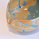 Ceramic bowl with blue and orange glaze on a white background