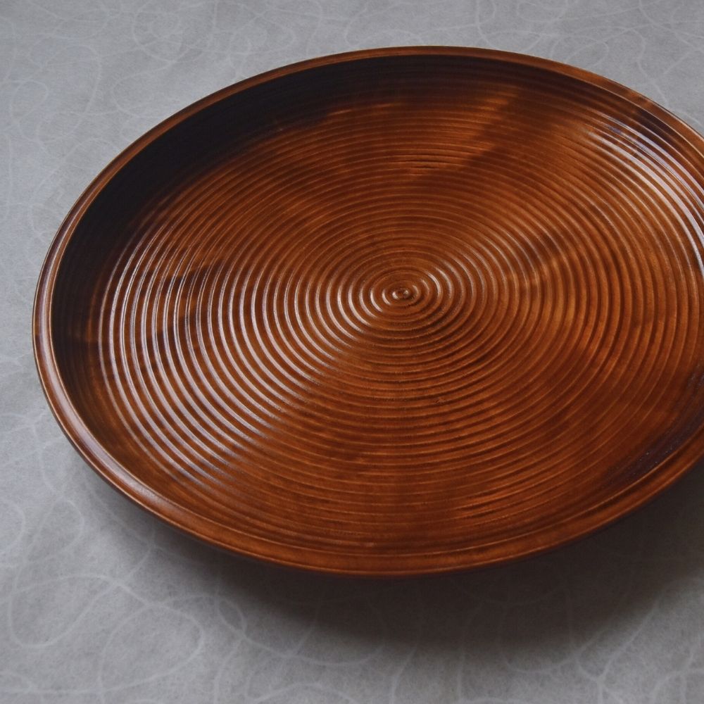 Brown wood tray with textured surface on a gray background