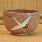 Ceramic bowl with a white bird design on a textured surface
