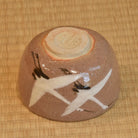 Ceramic bowl with artistic design on a woven mat