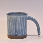 Blue ceramic mug with a textured surface on a white background