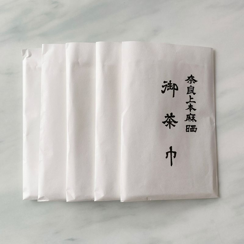 Five sets of white paper sachets of Chakin products from Nara Tea Co. with the product name on them