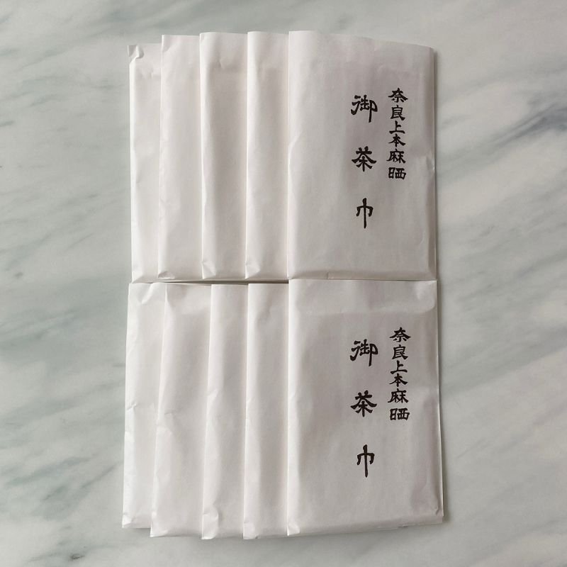 Ten sets of white paper sachets of Chakin products from Nara Tea Co. with the product name on them