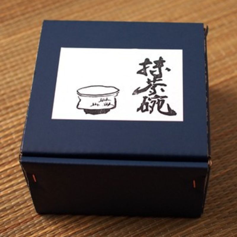 The Akashino Matcha Tea Bowl from Nara Tea Co. has a slightly rough texture and is packaged in an elegant orange color with an illustration of a bowl.