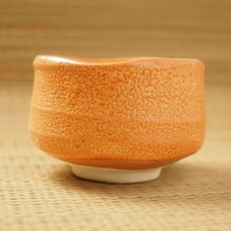 Akashino Matcha Tea Bowl from Nara Tea Co. with a slightly rough texture and an elegant orange color, viewed from the front from the side.
