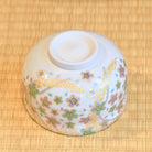 Decorative ceramic bowl with floral patterns on a bamboo mat