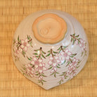 Ceramic bowl with floral patterns on a bamboo mat