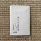 White rectangular product packaging with text on a woven mat background