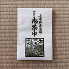 White napkin with black text and design on a woven mat background