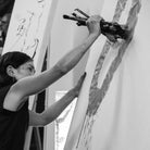 Person painting on a large canvas with a brush