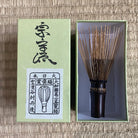 Tea whisk with its packaging on a wooden surface