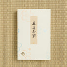 White product packaging with a beige tag on a woven mat background