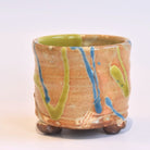 Ceramic pot with green and blue glaze on a white background