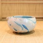 Ceramic bowl with blue accents on a woven mat