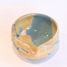 Ceramic bowl with blue and orange glaze on a white background