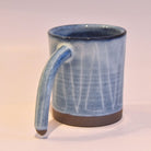 Blue ceramic mug with a handle on a white background