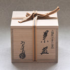 Wooden gift box with a ribbon and Japanese text on a neutral background